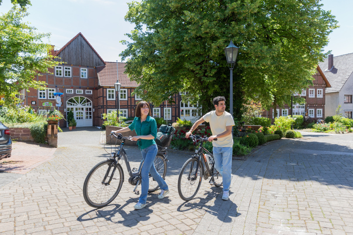 Zwei Radfahrer bei einer gef&uuml;hrten Radreise durch einen historischen Ortskern mit Fachwerkh&auml;usern
